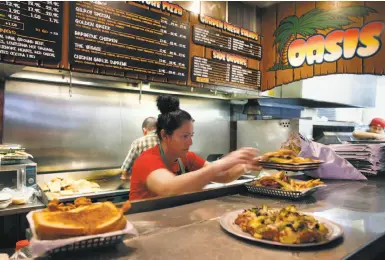  ?? Photos by Paul Chinn / The Chronicle ?? Violeta Duran fills orders at the Oasis Beer Garden, fondly known as “the O,” set to shut its doors March 7.