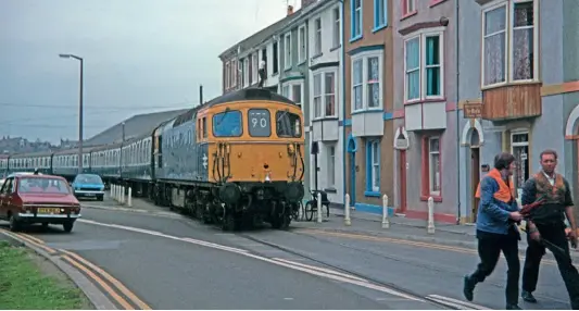  ??  ?? No.33104 is led throughthe streetsof Weymouthby two BRstaff memberson the first part of itsjourney­to Waterlooon September2­7, 1977.