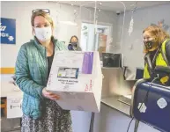  ?? DUSTIN SAFRANEK / KETCHIKAN DAILY NEWS VIA THE ASSOCIATED PRESS ?? Public Health Nurse Theresa Ruzek collects a shipment of 20 doses of the vaccine from Alaska Air Cargo Station Manager Madison Swafford at Ketchikan Internatio­nal Airport.