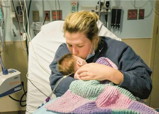  ?? LESTER GRAHAM/KAISER HEALTH NEWS 2022 ?? Caitlyn Houston kisses her daughter as they wait in the emergency department for a bed to open up at a children’s hospital in Michigan.