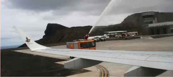  ?? (Ed Cropley/Reuters) ?? A FIRE TRUCK sprays water over the first commercial flight to land at St. Helena Airport, near Jamestown, on Saturday.