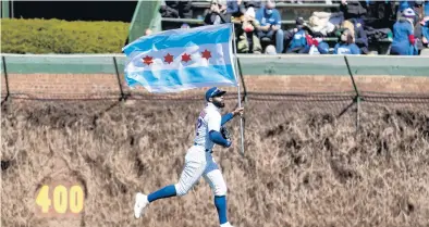  ?? BRIAN CASSELLA/CHICAGO TRIBUNE ?? Cubs right fielder Jason Heyward carries a Chicago flag onto the field before facing the Pittsburgh Pirates on on opening day at Wrigley Field in 2021.