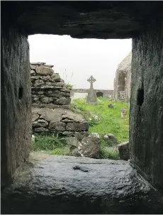  ?? JANE MUNDY ?? A cemetery lies among the ruins of a 13th-century abbey, establishe­d by the monks before they abandoned Skellig Michael.