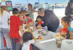  ?? ?? La chef Mariela Pérez Bocchio enseña a uno de los participan­tes a elaborar la ensalada de verano.