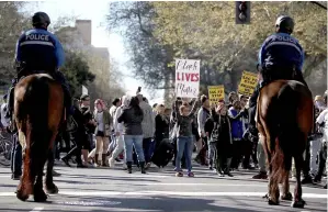  ??  ?? A young girl holds a Black Lives Matter sign in front of Sacramento police officers on horseback during a demonstrat­ion in Sacramento. — AFP photo