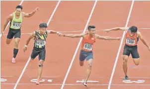  ??  ?? Selangor’s Muhammad Aqil Yasmin (second right) celebrates winning the men’s 100m. — Bernama photo