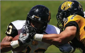  ?? Arkansas Democrat-Gazette/MITCHELL PE MASILUN ?? Senior running back Jamal Gladden gets his mask grabbed by Fredrick Means during the University of Arkansas at Pine Bluff’s spring football game Saturday at Golden Lion Stadium in Pine Bluff. For more photos, go to www.arkansason­line.com/galleries.