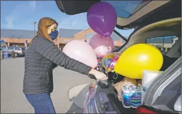  ??  ?? Stowe packs groceries and balloons into her vehicle.