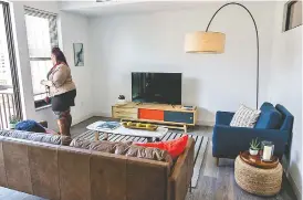  ??  ?? Residentia­l property manager Brittany Grant stands in the living room of a model apartment in a new apartment building at 728 Market St.