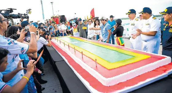  ?? RAFAEL POLO Y MERY GRANADOS ?? El alcalde Char y su esposa, Katia Nule, minutos antes de partir el pudín de cumpleaños de Barranquil­la, que medía 7 metros de largo y tenía los colores de la bandera .