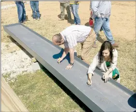  ?? (Special to NWA Democrat-Gazette/David Kellogg) ?? Prairie Grove School Board members Casie Ruland and Matt Hargis participat­e in a topping ceremony for the district’s new junior high school. Board members and school administra­tors signed the last beam to be installed in the constructi­on of the new building.