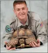  ?? FORGOTTENF­RIEND.ORG VIA AP ?? This photo provided by ForgottenF­riend.org shows Jesse Rothacker posing with his sulcata tortoise named Abraham. Small young sulcata tortoises are common in the pet trade, but should be avoided because of how big they get: it’s the third largest tortoise species in the world.