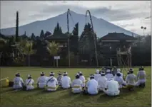  ?? ULET IFANSASTI, GETTY IMAGES ?? Balinese Hindu worshipper­s pray at Besakih temple in the danger zone from Mount Agung, seen on the background Sunday in Karangasem regency, Island of Bali, Indonesia.