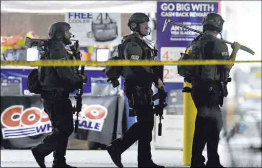  ?? Will Lester The Associated Press ?? Police officers respond to a shooting Friday at a Costco Wholesale store in Corona, Calif. An off-duty police officer opened fire in the store, killing his assailant and wounding two others, officials said.