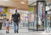  ?? STAFF PHOTO BY ERIN O. SMITH ?? Brendon Rembert, 4, walks around Hamilton Place mall with his father, Marco Rembert Monday.