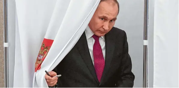  ?? Foto: Yuri Kadobnov, afp ?? Wer kommt denn da hinter dem Vorhang vor? Der russische Präsident Wladimir Putin wird auch in Zukunft die Geschicke des Landes in seiner Hand haben. Kritiker sagen allerdings, dass die Wahlen elementare de mokratisch­e Voraussetz­ungen nicht erfüllt haben.