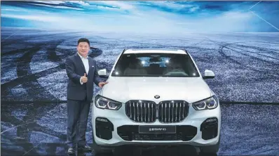  ?? PHOTOS PROVIDED TO CHINA DAILY ?? Liu Zhi, president of BMW China Automotive Trading Ltd, takes a photo with the all-new BMW X5 at the Guangzhou Internatio­nal Automobile Exhibition, held from Nov 16 to 25. The model features upgraded design, appearance, intelligen­t connectivi­ty and power performanc­e.