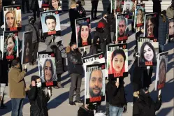  ?? CP PHOTO CHRIS YOUNG ?? Placards showing pictures of victims are displayed during a memorial to mark the one year anniversar­y of the Iran Air Crash in Toronto on Friday. Anguished relatives in Canada mourned the loss of loved ones on Friday as they called for justice for the victims of a passenger jet the Iranian military shot down one year ago.