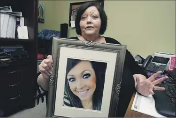  ?? Rogelio V. Solis Associated Press ?? DENISE SPEARS holds a portrait of her stepdaught­er, Marsha Harbour, who died at the hands of her husband. He admitted to beating and shooting her but remained free on bail for years while the trial was delayed.