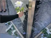  ??  ?? MORE THAN 6,000 names are etched in the memorial, where families lay f lowers and take photos.