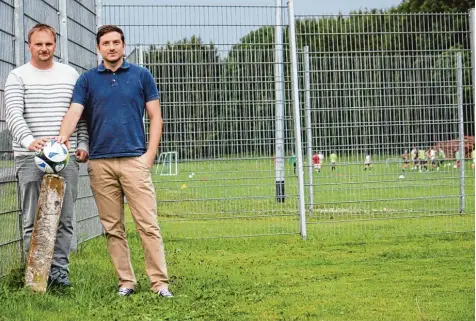  ?? Foto: Axel Schmidt ?? Der Fußball verbindet: Sebastian Schulz (links/SpVgg Wiedergelt­ingen) und Benedikt Hartung (rechts/FSV Amberg) stehen am Grenzstein, der die Fluren Ambergs und Wie dergelting­ens am Sportplatz Amberg trennt. Diese Grenze wird sportlich nun überwunden – beide Vereine gehen eine Spielgemei­nschaft ein.