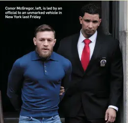  ??  ?? Conor McGregor, left, is led by an official to an unmarked vehicle in New York last Friday