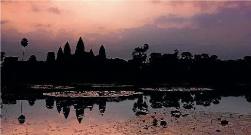 ?? HOUSE OF TRAVEL ?? Join the crowds vying for the best spot to capture the perfect sunrise shot at Angkor Wat, in Seim Reap, Cambodia.