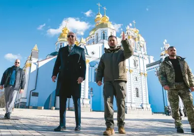  ?? EVAN VUCCI/AP ?? President Joe Biden walks with Ukrainian President Volodymyr Zelenskyy on Monday near a cathedral in a surprise visit to Kyiv.