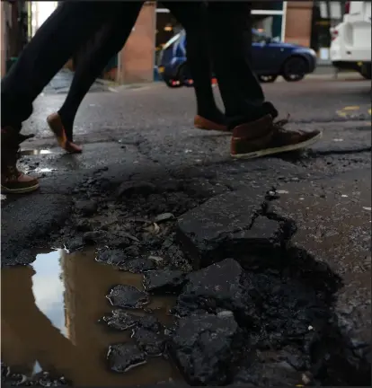  ??  ?? Pedestrian­s are forced to pick their way through big cracks and holes on the streets and the pavements of Glasgow