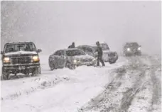  ?? MIKE DE SISTI, MILWAUKEE JOURNAL SENTINEL, VIA AP ?? Drivers help one another Sunday after several cars spun out on Interstate 43 northbound near Port Washington, Wis.