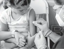  ?? DANIEL A. VARELA dvarela@miamiheral­d.com ?? Mia Diaz, 7, prepares to get a COVID-19 vaccine at Tropical Park in west Miami-Dade County on June 25. The state has logged 76,489 COVID-19 deaths since March 2020.