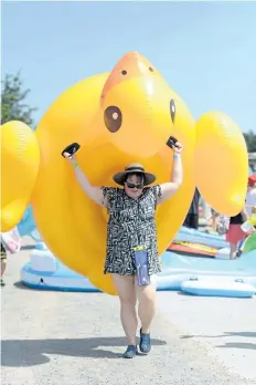  ?? DAVE JOHNSON/POSTMEDIA NEWS ?? Bethany Desjardine­s carries a giant inflatable yellow duck to the canal.