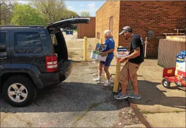  ?? CHAD FELTON — THE NEWS-HERALD ?? Lois Palmer, of Willowick Food Pantry, and Moving Ahead Services employee Adam Woodard, load Palmer’s truck on May 9 during the 26th Annual Feed Lake County program at United Way of Lake County’s temporary warehouse in Mentor. The nonprofit...