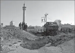  ??  ?? EXPLOSION SITE: In this photo released by the Syrian official news agency SANA, Syrian soldiers stand at the explosion site where a car bomb exploded near the shrine of Sayyida Zeinab, seen in the background, suburb of Damascus, Syria on Thursday. A...