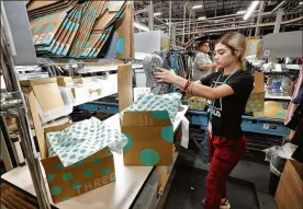  ?? MATT YORK / AP ?? Yakaranday Arce packs sold clothing for shipment at the ThredUp sorting facility in Phoenix. J.C. Penney and Macy’s are in the midst of rolling out a few dozen ThredUp branded shops each in time for the back-to-school shopping season.