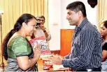  ??  ?? The author (right) presenting a copy of the book to one of his former teachers. Pix by Indika Handuwala