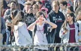  ?? Mike Stocker South Florida Sun Sentinel ?? MARJORY STONEMAN High School students gather on the football field during the walkout against gun violence. Middle schoolers from next door joined in.