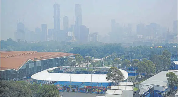  ?? REUTERS ?? A view of the city skyline shrouded by smoke haze from bushfires during an Australian Open practice session in Melbourne on Tuesday.