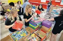  ?? SUSAN STOCKER/SUN SENTINEL ?? Amanda Schneider, 16, Carrie Woodford, 15, and Amanda Campos, 15, pack school supplies in June 2019 as they volunteere­d for a Kiwanis Club program.