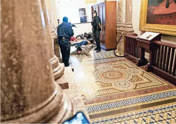  ??  ?? la policía del Capitolio detiene a miembros de la turba que tomó el Congreso en Washington