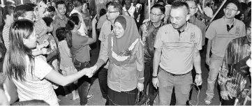  ??  ?? Azizah (centre) greeted by one of the residents on arrival to launch the Beaufort-level Chinese New Year 2015 carnival and lantern festival.