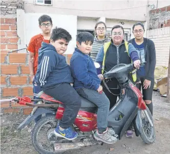  ?? EMMANUEL BRIANE-LA NUEVA. ?? INÉS JUNTO a cinco de sus siete hijos y su "herramient­a de trabajo", la motociclet­a.