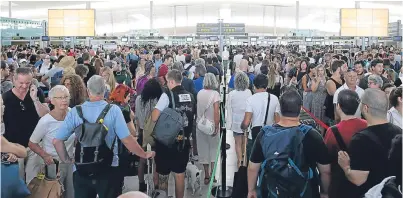  ?? Picture: AP. ?? Passengers wait to pass the security control at Barcelona’s airport at El Prat de Llobregat.