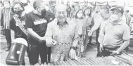  ?? — Gambar Roystein Emmor ?? TERTARIK: Uggah ketika melawat gerai Bazar Festival Gawai 2022 di Kuching, malam kelmarin.