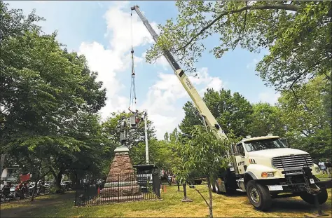  ?? Peter Hvizdak / Hearst Connecticu­t Media ?? Workers remove the statue of Christophe­r Columbus from Wooster Square Park in New Haven on June 24.