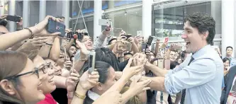  ?? ADRIAN WYLD/THE CANADIAN PRESS ?? Prime Minister Justin Trudeau shakes hands as he walks through a building’s lobby in Manila, Philippine­s, on Monday.