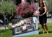  ??  ?? Christine Bianchi pose devant un tableau représenta­nt la Marussia de son fils. Une oeuvre d’Olivier Tramoni mise aux enchères ce vendredi à Bandol. Les bénéfices iront à l’hôpital L’Archet de Nice, où Jules a lutté pendant neuf mois après son accident.