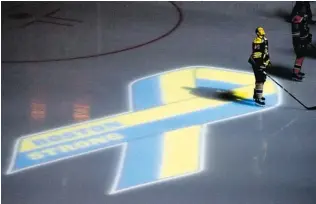  ?? JIM ROGASH/ GETTY IMAGES ?? Bruins defenceman Dennis Seidenberg stands near an on- ice projection of the Boston Marathon Memorial Ribbon before Wednesday’s game against the Buffalo Sabres at TD Garden.