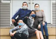  ?? Cloe Poisson / Contribute­d photo ?? Julio Ortega and his wife, Olga Gutierrez, sit on the front steps of the two-family house where they live with their two children, Julio Jr., 11, and Gissel, 17, and twelve other family members in Bridgeport. Two members of their extended family recently tested positive for COVID-19 — Gutierrez’s sister, who is quarantine­d in a bedroom in their apartment, and her brother-in-law who is hospitaliz­ed. The family is unable to get tested for the virus because they are not exhibiting symptoms.