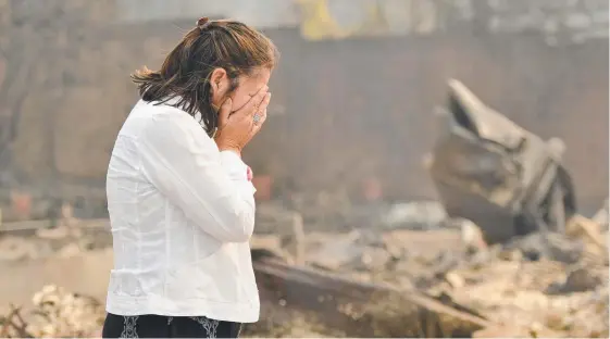  ?? Picture: AFP ?? Homeowner Martha Marquez breaks down as she walks around her burned home in Santa Rosa, California. The wildfires tearing through California wine country exploded in size and number as high winds fuelled the flames.